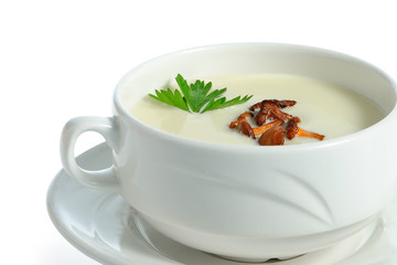 Cream soup with chanterelle mushrooms in ceramic bowl on white