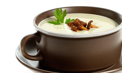Cream soup with chanterelle mushrooms in ceramic bowl on white