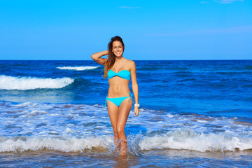 Fototapeta na wymiar Brunette happy girl walking in the beach shore