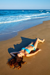 Fototapeta na wymiar Beatifull brunette girl lying on beach sand