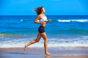 Beautiful brunette girl running in a summer beach