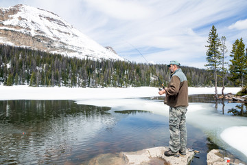 Fototapeta na wymiar Man fishing in mountain Mirror Lake. Uinta-Wasatch-Cache Natio