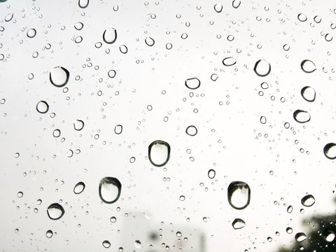 Rain Water droplets on glass window with blurred background. Raindrops. Water drops.