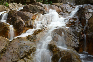 Naklejka na ściany i meble Small Waterfalls flowing over the rock.