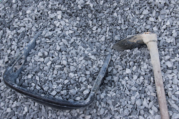 pile crushed stone and hoe , Buckets for construction.