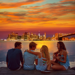 Fototapeta na wymiar Friends group playing guitar in sunset pier at dusk