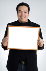 Asian man in black suit holds an empty white board