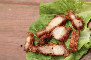 Pork fried with vegetables on wood background.