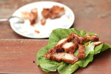Pork fried with vegetables on wood background.