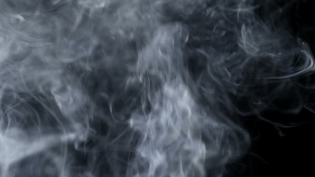 Smoke slow floating in space against black background
