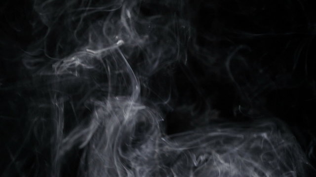 Smoke slow floating in space against black background
