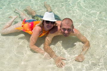 Couple during summer vacation on the beach bathing in the water