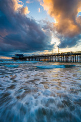 Waves in the Pacific Ocean and the Newport Pier at sunset, in Ne