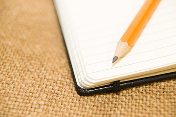 Opened notebook and pencil on the old tissue