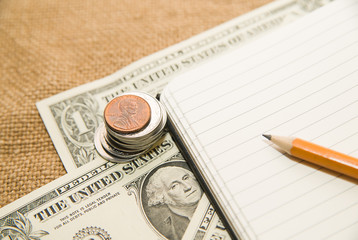 Opened notebook, pencil and money on the old tissue
