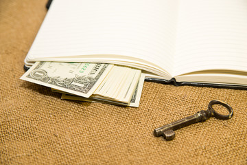 Opened notebook, keys and money on the old tissue