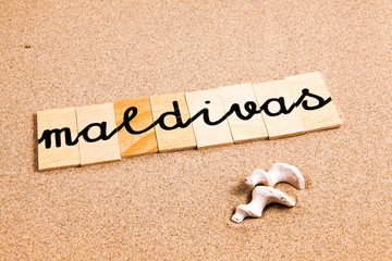 Words formed from small pieces of wood containing a sun and beach tourist destination, Maldivas