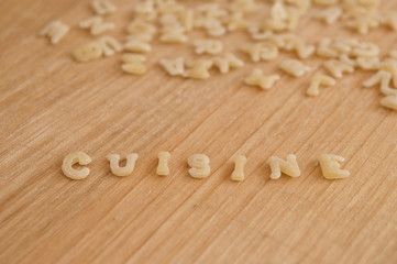 p&acirc;tes alphabet avec mot "cuisine" sur planche en bois