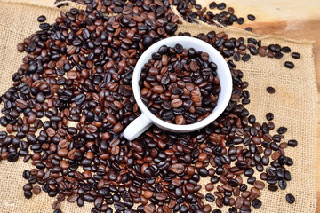 Cup full of coffee beans on the cloth sack