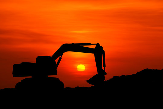 silhouette of excavator machine with sunset