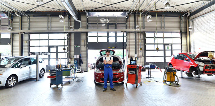 car mechanic in a garage with vehicles // moderne Autowerkstatt