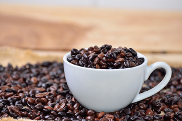 Cup full of coffee beans on the cloth sack