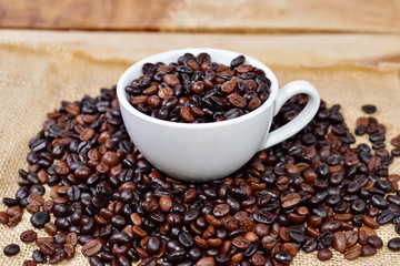 Cup full of coffee beans on the cloth sack
