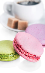 Cup of coffee and macaroons on white background