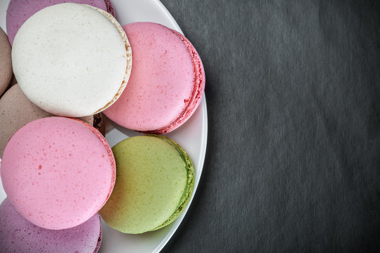 Sweet and colourful french macaroons on a black background