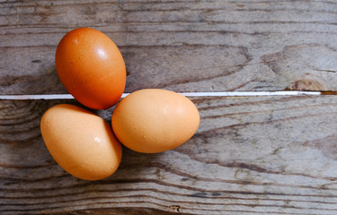 Three eggs lay on a wooden table