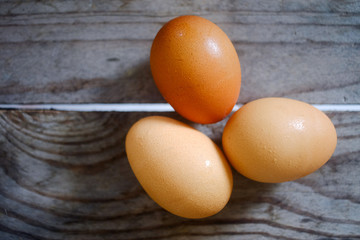 Three eggs lay on a wooden table