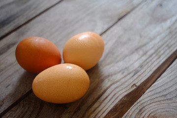 Three eggs lay on a wooden table