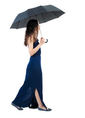 young woman in dress walking under an umbrella