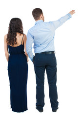 young couple pointing at wal Back view