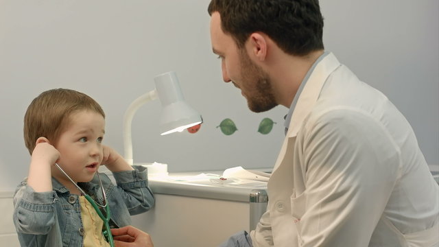 Young boy listening to doctor's heart with stethoscope