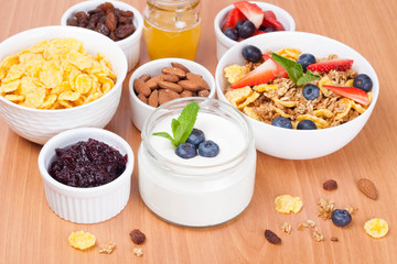 homemade yogurt with fresh berries and breakfast foods on table