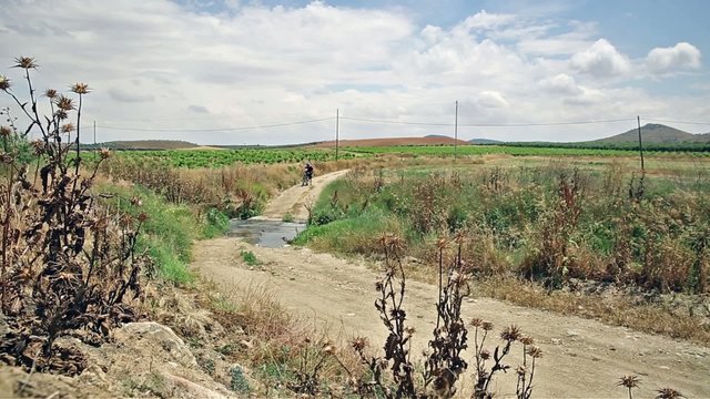 Bicycle touring through the countryside, crossing a brook