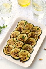 Antipasto of grilled courgette zucchini with olive oil and pine
