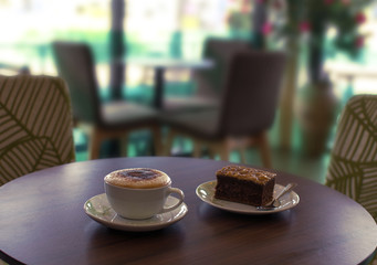 Cup of coffee and a cake on the table in cafe