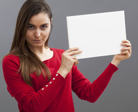 unhappy young woman with a red sweater holding a blank message on board for marketing communication