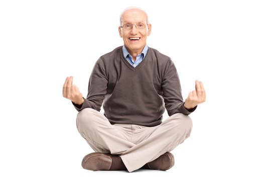 Senior gentleman meditating seated on the floor - Powered by Adobe