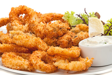 Plate of fried in batter squid  with sauce.