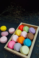 Macaron in a wooden box on black, Vintage tone