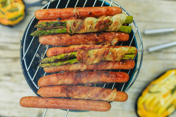 Grilled sausages and asparagus with bacon