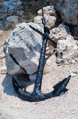 Old black ship anchor and stone in Podgora, Croatia
