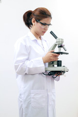 Young female tech or Scientist using a microscope in a laboratory