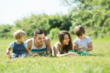 Fototapeta premium Czteroosobowa rodzina w słonecznym parku