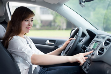 Fototapeta na wymiar asian femle driver touching dashboard in car