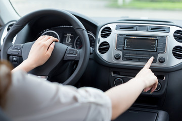 asian femle driver touching dashboard in car