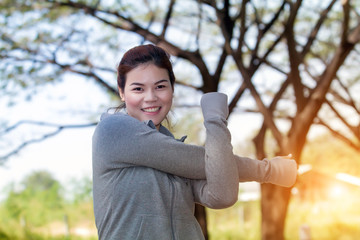 Athletic woman asia warming up and Young female athlete sitting on an exercising and stretching in a park healthy lifestyle concept.